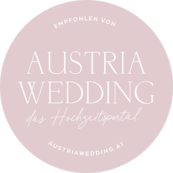 Rosa rundes Logo mit der Aufschrift "Austria Wedding – das Hochzeitsportal".